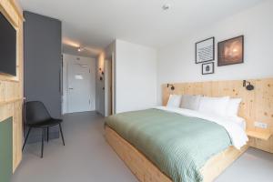 a bedroom with a large bed and a chair at stuub freiburg in Freiburg im Breisgau