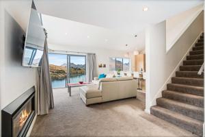 a living room with a couch and a fireplace at Lakeview Retreat - Queenstown Holiday Home in Queenstown