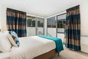 a bedroom with a bed and a large window at Lakeview Retreat - Queenstown Holiday Home in Queenstown