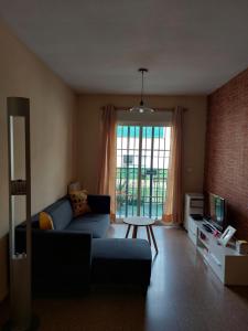 a living room with a blue couch and a tv at Home&Holidays Las Gabias, Granada in Las Gabias