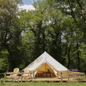 維琪奧港的住宿－Domaine Authentique de Rose，田野里带椅子和树木的帐篷