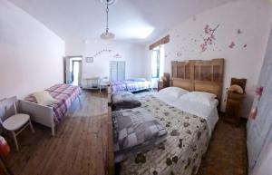 a large bedroom with two beds and a couch at Il gioco dell'oca in Ponna Superiore