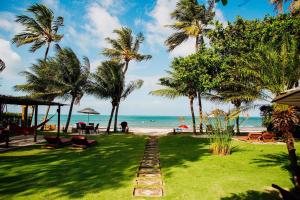 um caminho para a praia com palmeiras e o oceano em Pousada Village Porto Mirim pé na areia por Carpediem em Ceará-Mirim