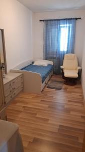 a bedroom with a bed and a chair in it at MERICA Kneže in Korčula