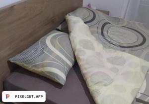 two pillows sitting on top of a bed at Comfort Apartment in Tirana