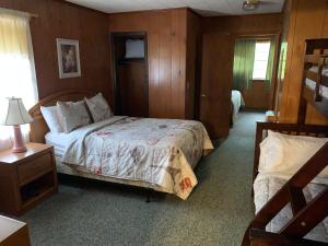 Phillips Historic Motel & Cottages في روبينسفيل: غرفة نوم بسرير وموقف ليلي مع مصباح