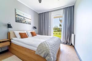 a bedroom with a bed and a window at Marina Blue Iława in Iława