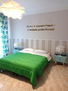 a bedroom with a green bed with a sign on the wall at Suite Liberty in Taranto