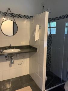 a bathroom with a sink and a shower with a mirror at Chales em Salesopolis - Recanto da Barra in Salesópolis