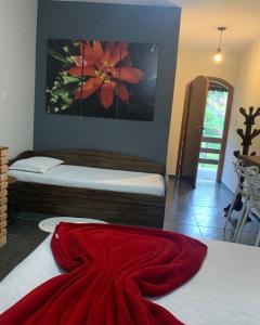 a bedroom with two beds and a red blanket on the floor at Chales em Salesopolis - Recanto da Barra in Salesópolis