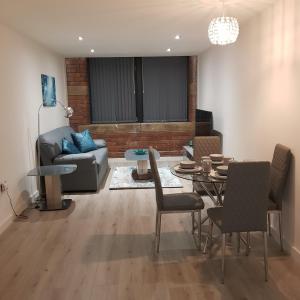 a living room with a couch and a table and chairs at Luxury Serviced Apartments in Bradford