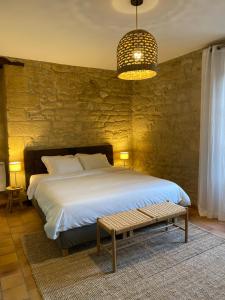 a bedroom with a large bed and a table at Les Courtines - Appartement de caractère à la Roque-Gageac - Les Lauriers in La Roque-Gageac