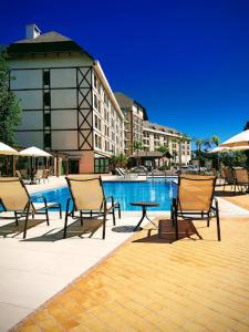 a group of chairs and a table next to a pool at Condomínio Vista Azul in Aracê