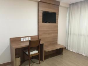 Aracê的住宿－Condomínio Vista Azul，一间房间,配有一张桌子和一台墙上的电视