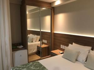 a bedroom with a large mirror behind a bed at Condomínio Vista Azul in Aracê +8 photos