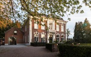 a large brick house with an archway at Villa Polder - Boutique Hotel near Eindhoven in Gemert