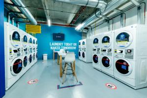 a row of white washing machines in a laundry room at CentralX 18 in Bogotá