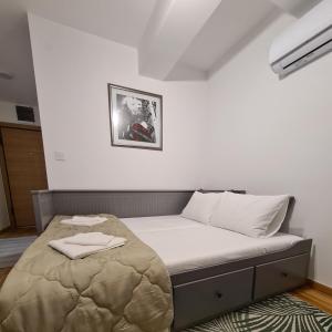 ein Schlafzimmer mit einem Bett in einem weißen Zimmer in der Unterkunft New Now Living in Novi Sad