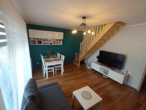 a living room with a dining room table and a staircase at Apartament Moris in Puck