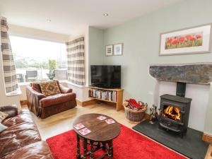 a living room with a couch and a fireplace at 5 Ivy Terrace in Porthmadog