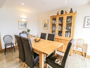 uma sala de jantar com uma mesa de madeira e cadeiras pretas em 5 Ivy Terrace em Porthmadog