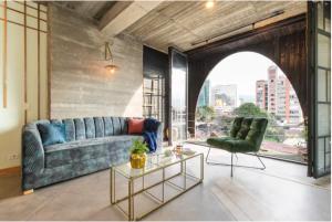 sala de estar con sofá, silla y mesa en Nido Sky en Medellín