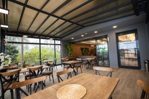 ein Restaurant mit Tischen, Stühlen und Fenstern in der Unterkunft Marina Green Suite & Residence in Trabzon