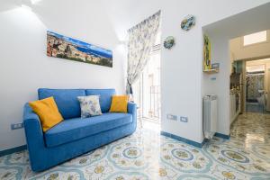 - un canapé bleu dans le salon orné d'une peinture murale dans l'établissement SereMatte al 26, à Naples
