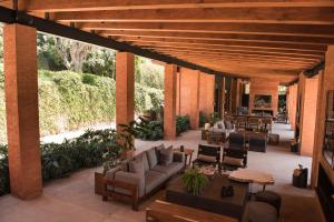 un patio esterno con divani, tavoli e piante di Hotel Avandaro Golf & Spa Resort a Valle de Bravo
