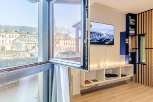 a room with a large window and a tv at Suite "comme à Venise" vue sur Metz Opéra avec parking inclus in Metz