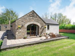 a stone house with a patio and a yard at Highbury in Spittal