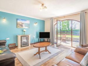 a living room with a table and a tv at Highbury in Spittal