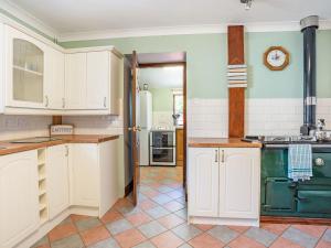 a kitchen with white cabinets and green appliances at Highbury in Spittal