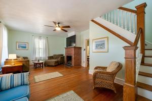 a living room with a ceiling fan and a fireplace at Captains Quarters by the Bay cottage in Norfolk