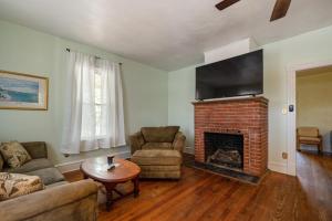 a living room with a fireplace and a flat screen tv at Captains Quarters by the Bay cottage in Norfolk