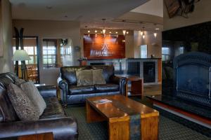 a living room with leather furniture and a fireplace at Allington Inn & Suites Kremmling in Kremmling