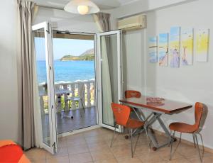 ein Esszimmer mit einem Tisch und Meerblick in der Unterkunft Chrispy Apartments in Syvota