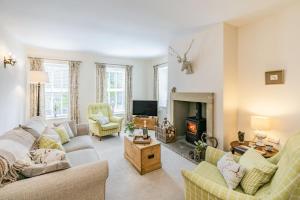 sala de estar con sofá y chimenea en St John's Cottage en Penistone