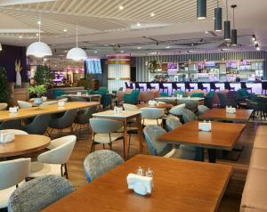 a restaurant with wooden tables and chairs and a bar at YOTEL Istanbul Airport, City Entrance in Istanbul
