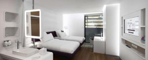 a white room with a bed and a mirror at YOTELAIR Istanbul Airport, Duty free - International Transit area in Istanbul