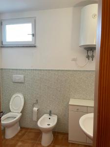 a bathroom with a toilet and a sink at Incantevole appartamento Sole, in centro in Stintino