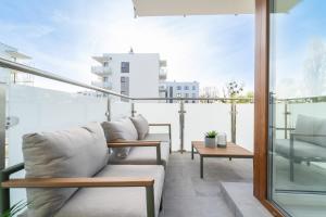 balkon z 2 kanapami i stołem w obiekcie Bella Vista - 3pok, 5 łóżek, centrum, parking, winda, widok na rzekę, Netflix w Iławie