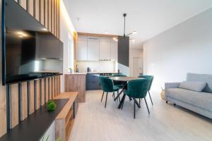 a kitchen and living room with a table and chairs at Bella Vista Apartment in Iława