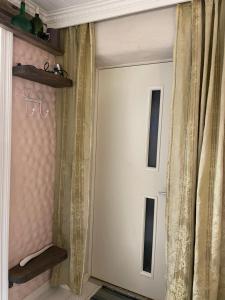 a white door in a room with curtains at Renthouse Guest Apartment ALICE in Paide