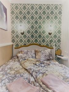 a bedroom with a bed with a green and white wallpaper at Renthouse Guest Apartment ALICE in Paide