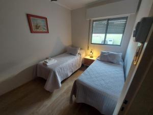 1 Schlafzimmer mit 2 Betten und einem Fenster in der Unterkunft Castellanos Departamento Temporario in Santa Fe