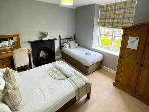 a bedroom with two beds and a fireplace in it at The Farm House in Llangollen