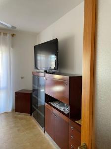 a entertainment center with a flat screen tv on top of it at Incantevole appartamento Sole, in centro in Stintino +9 photos