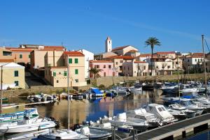 a group of boats docked in a marina with buildings at Incantevole appartamento Sole, in centro in Stintino