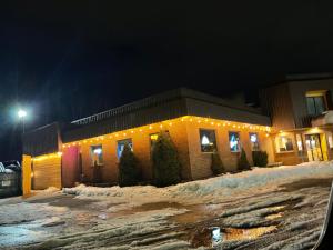 a building with christmas lights in the snow at night at America's Best Value Inn in Sandpoint